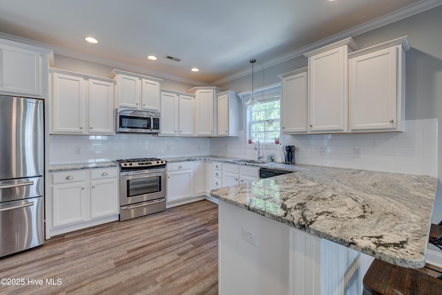 519 W Craftsman Way, Hampstead, NC 28443 - kitchen featuring appliances with stainless steel finishes, a sink, white cabinets, a peninsula, and ornamental molding