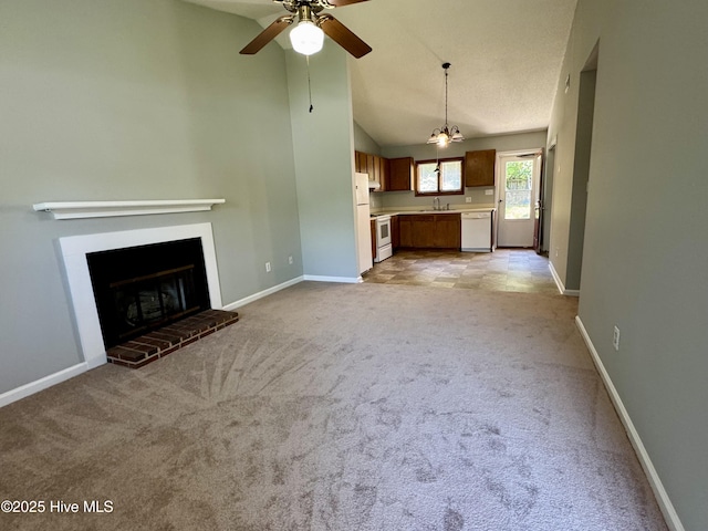 unfurnished living room featuring light colored carpet, a sink, ceiling fan, baseboards, and high vaulted ceiling