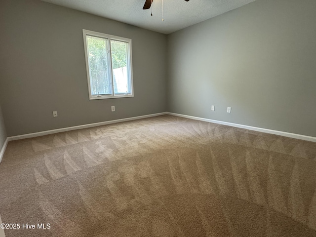 unfurnished room with ceiling fan, baseboards, carpet, and a textured ceiling
