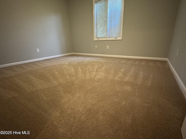 carpeted empty room with baseboards