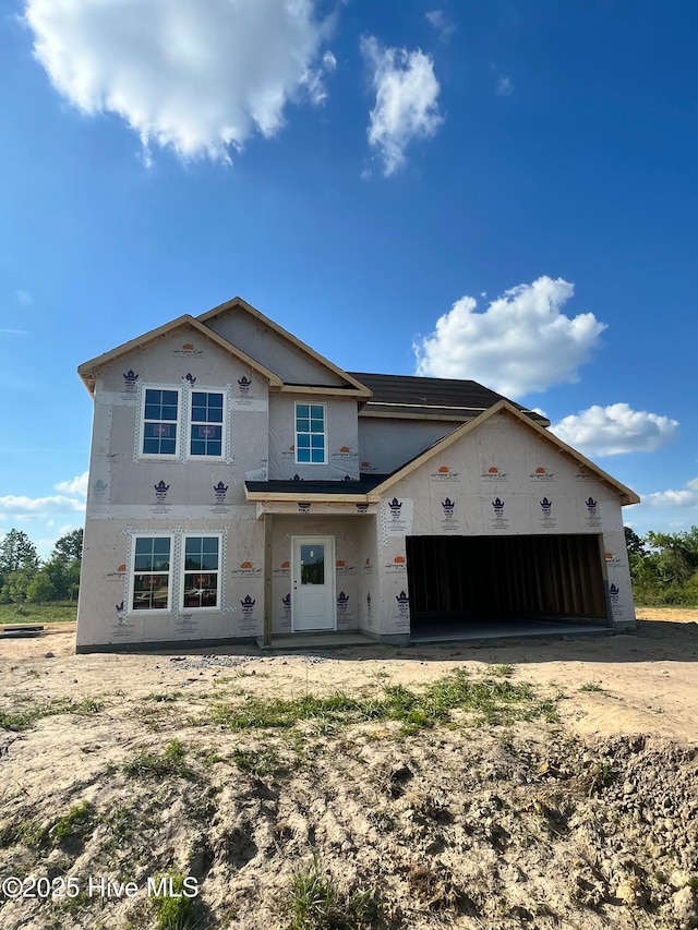unfinished property with a garage, stucco siding, and driveway