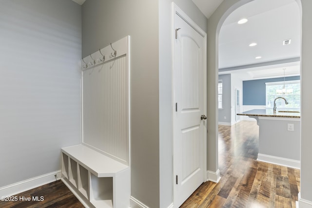 mudroom featuring arched walkways, dark wood-style floors, a sink, baseboards, and recessed lighting