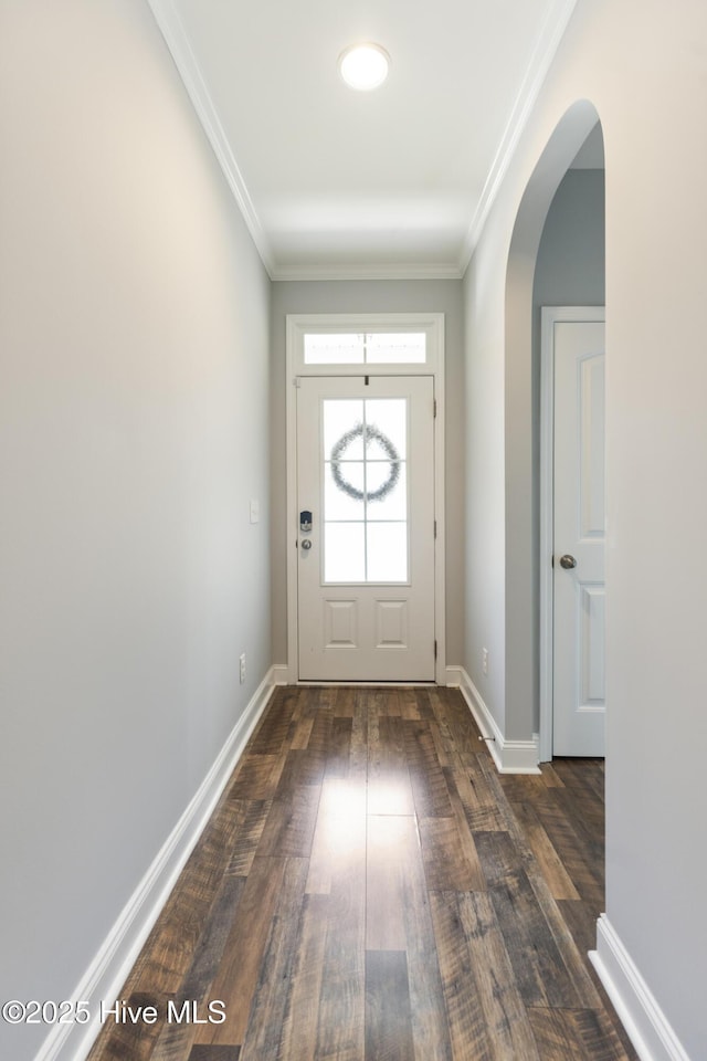 doorway to outside featuring crown molding, dark wood-style floors, baseboards, and arched walkways