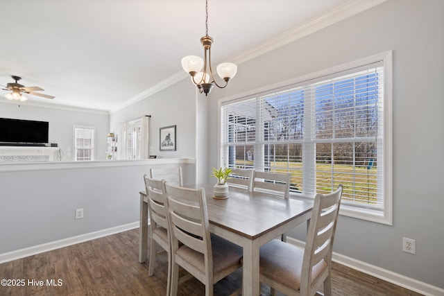 dining room with ceiling fan with notable chandelier, ornamental molding, baseboards, and wood finished floors