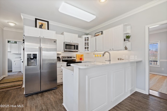 kitchen with dark wood-style flooring, washer / dryer, appliances with stainless steel finishes, and glass insert cabinets