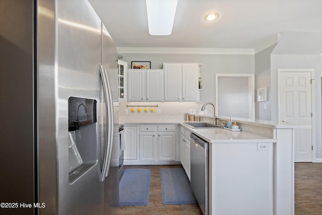 kitchen featuring a sink, open shelves, a peninsula, appliances with stainless steel finishes, and dark wood-style floors