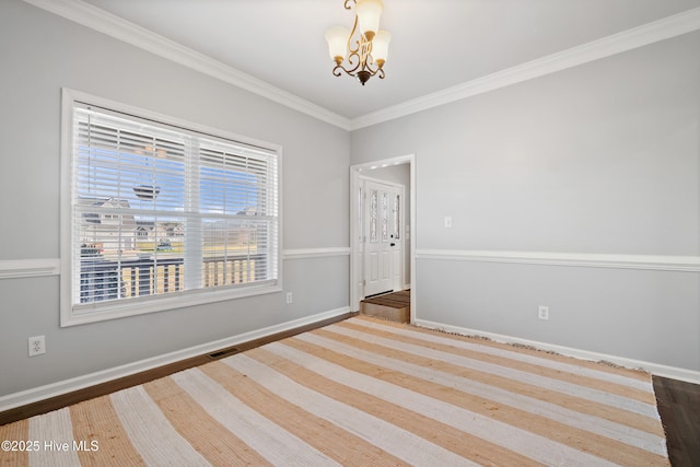empty room featuring ornamental molding, a notable chandelier, visible vents, and baseboards