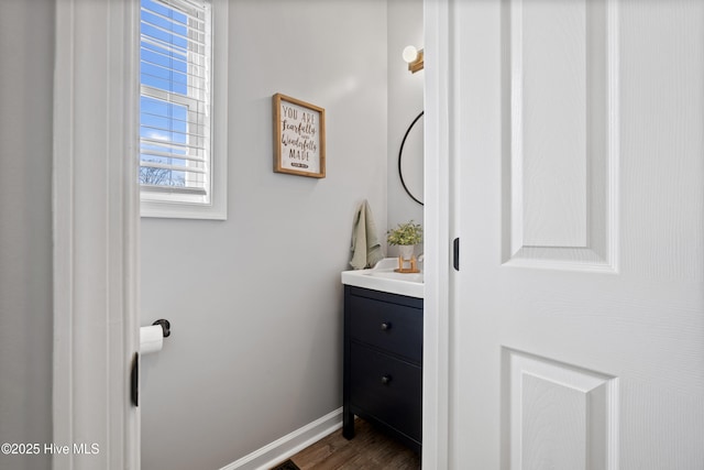 bathroom featuring vanity, baseboards, and wood finished floors