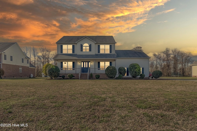 view of front of home with covered porch and a lawn