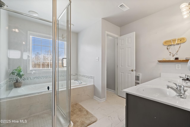 bathroom with double vanity, a sink, a bath, visible vents, and marble finish floor