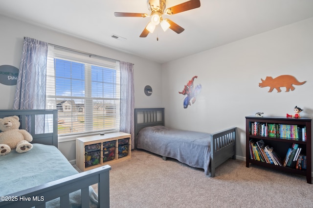 bedroom featuring a ceiling fan, visible vents, and carpet