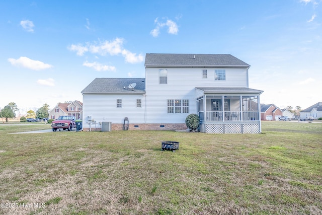 rear view of house featuring central AC, a lawn, an outdoor fire pit, a sunroom, and a shingled roof