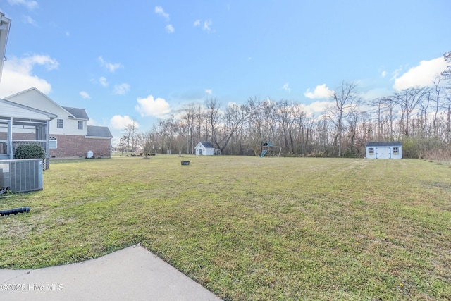 view of yard with central AC unit, an outdoor structure, and a shed