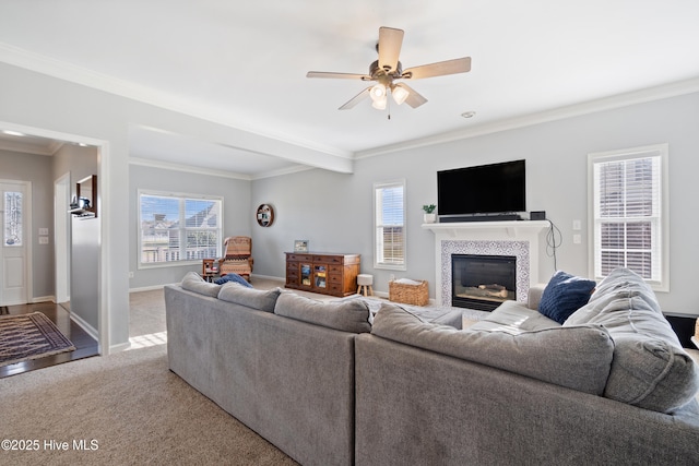 living area with a wealth of natural light, ornamental molding, a tile fireplace, and carpet