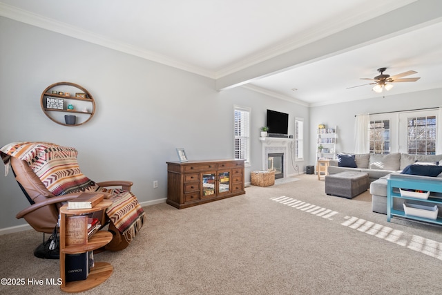 carpeted living area with crown molding, baseboards, and plenty of natural light