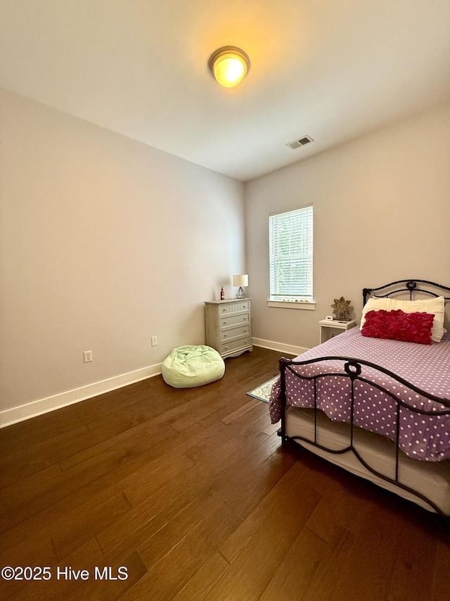 bedroom with wood finished floors and baseboards