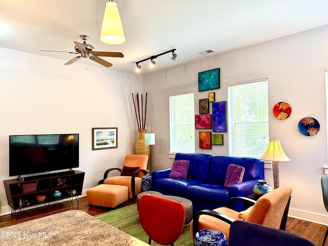living area featuring wood finished floors, baseboards, ceiling fan, and track lighting