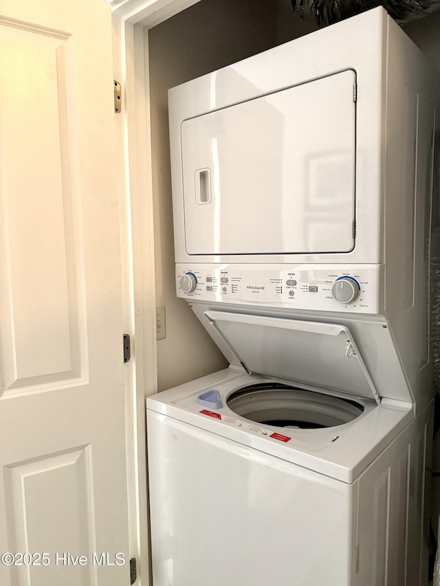 laundry area featuring stacked washer / drying machine