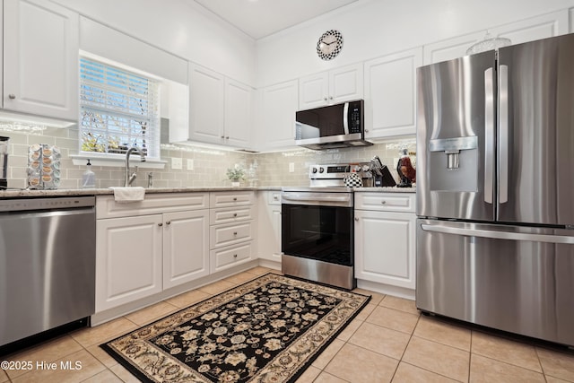 417 Pennington Loop, Myrtle Beach, SC 29588 - kitchen with stainless steel appliances, a sink, white cabinetry, backsplash, and light tile patterned floors