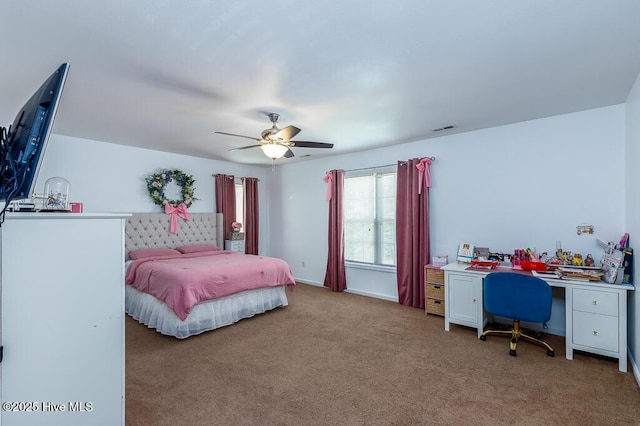 carpeted bedroom featuring an office area and a ceiling fan