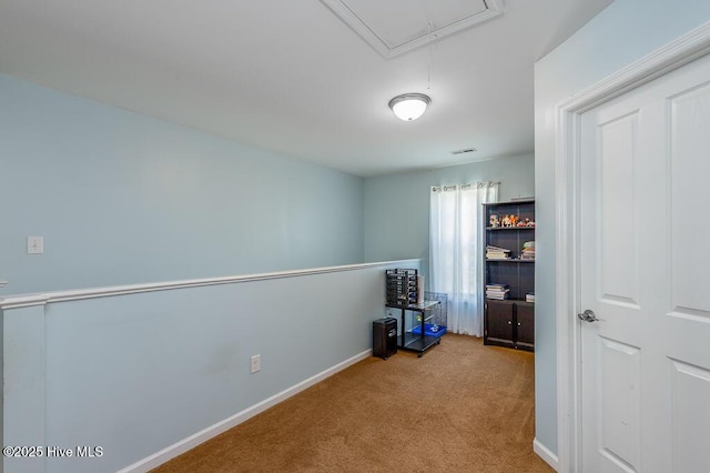 unfurnished bedroom with attic access, carpet, and baseboards