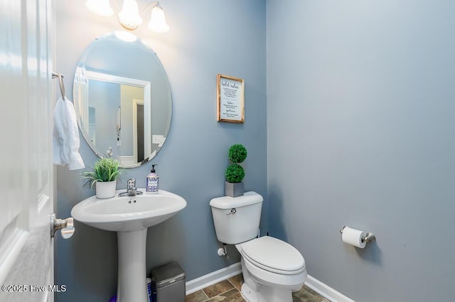 bathroom with toilet and baseboards