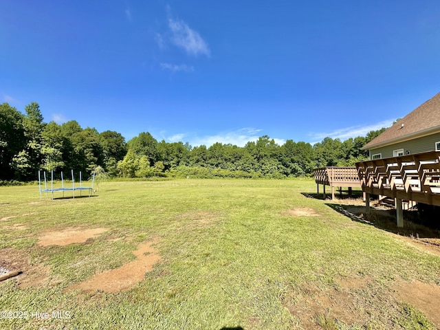 101 Pete Bunch Ln, Hobbsville, NC 27946 - view of green lawn featuring a trampoline, a deck, and a view of trees