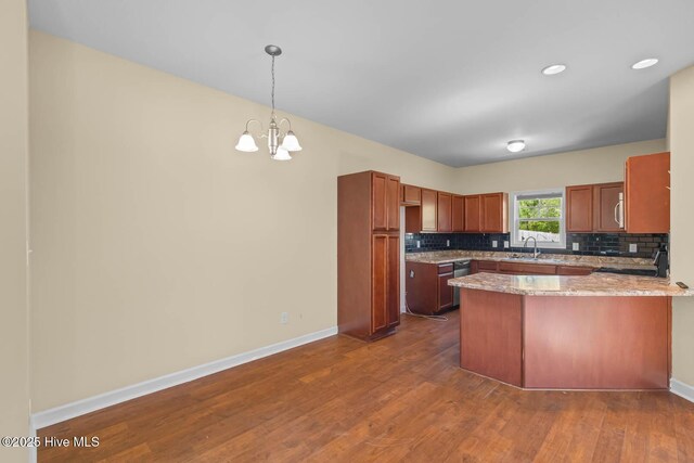 323 Frisco Way, Holly Ridge, NC 28445 - kitchen featuring a peninsula, decorative backsplash, a chandelier, dark wood-style flooring, and hanging light fixtures