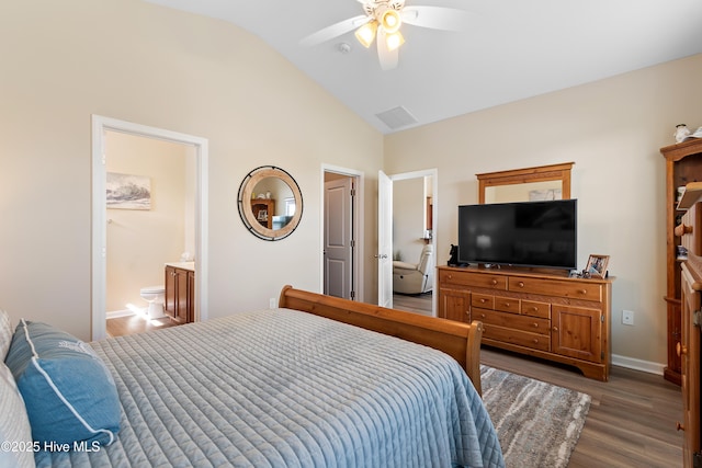 bedroom featuring lofted ceiling, wood finished floors, baseboards, a ceiling fan, and connected bathroom