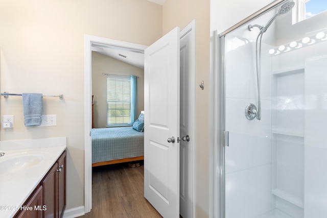 ensuite bathroom with a stall shower, wood finished floors, and vanity