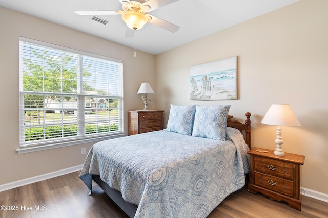 bedroom featuring baseboards, wood finished floors, and ceiling fan