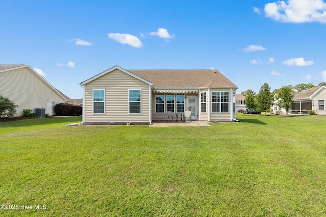 back of property featuring central AC unit, a patio area, a yard, and a shingled roof