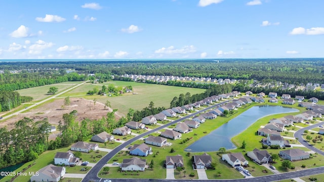 aerial view of property's location with nearby suburban area, a heavily wooded area, and a nearby body of water