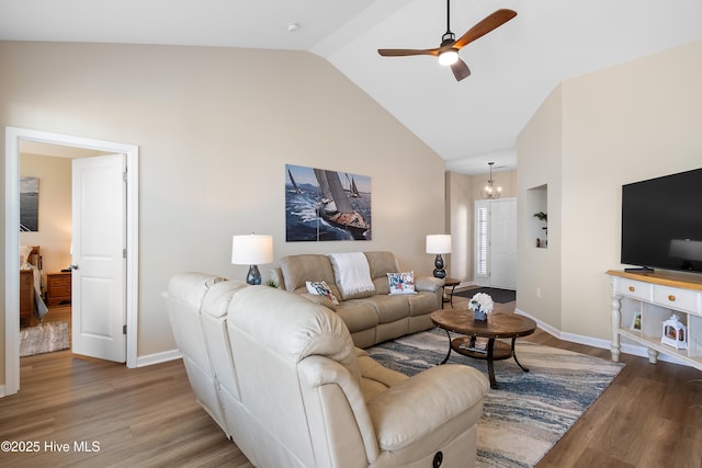 living area with ceiling fan, wood finished floors, high vaulted ceiling, and baseboards