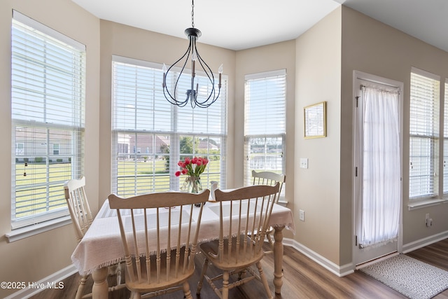dining area featuring baseboards, a chandelier, wood finished floors, and plenty of natural light