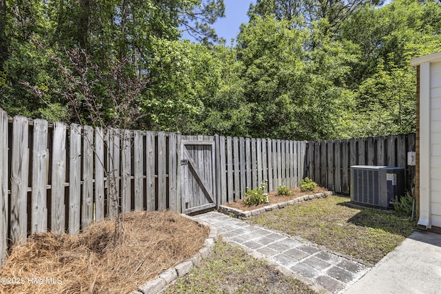 view of yard with central air condition unit, a gate, and a fenced backyard