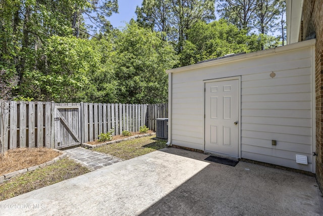 view of shed with central air condition unit, a gate, and a fenced backyard