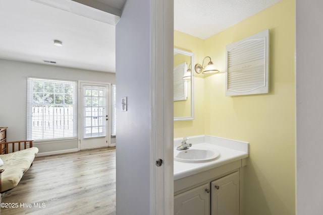 bathroom featuring vanity, visible vents, and wood finished floors