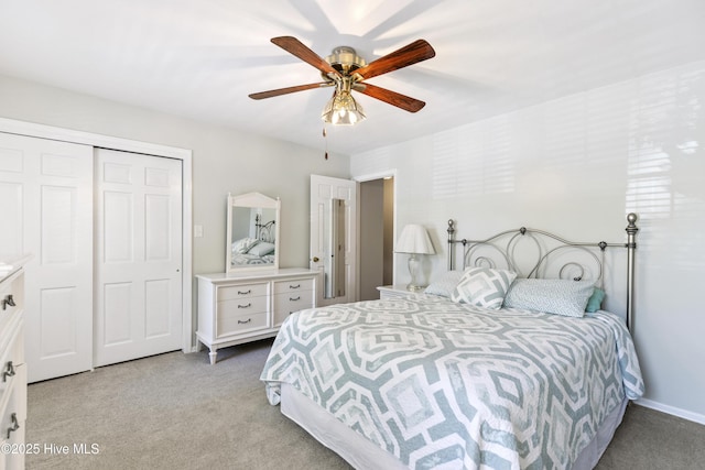 bedroom with a ceiling fan, a closet, and light colored carpet
