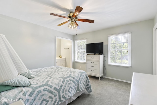 carpeted bedroom with baseboards, ensuite bathroom, and ceiling fan