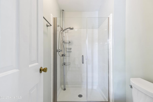 full bath with toilet and a stall shower