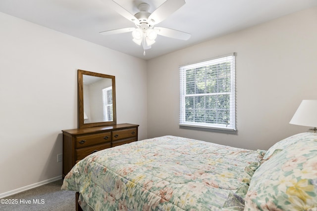 carpeted bedroom with ceiling fan and baseboards