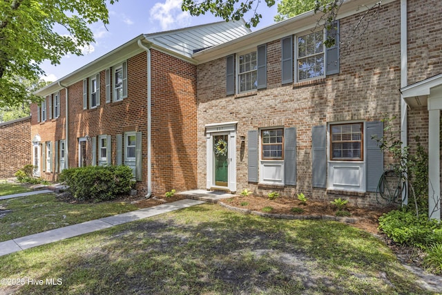 view of front of home with brick siding and a front lawn