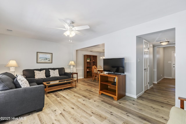 living area with ceiling fan, baseboards, visible vents, and wood finished floors