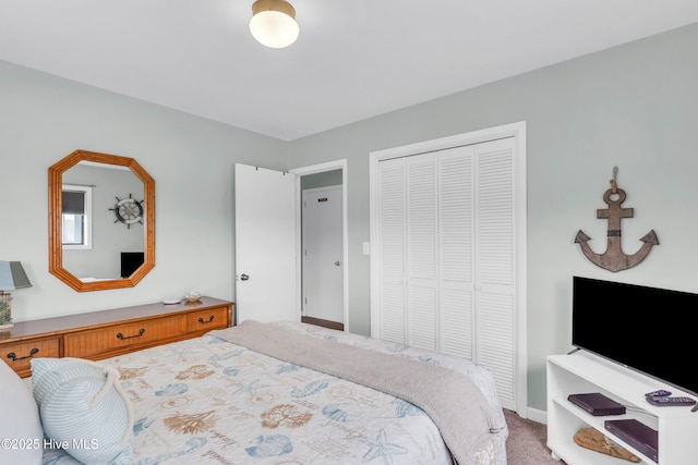 carpeted bedroom featuring a closet and baseboards