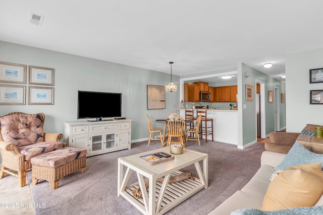 living area featuring light colored carpet, baseboards, and a chandelier