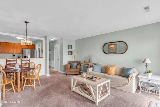living room with a chandelier, light colored carpet, and baseboards
