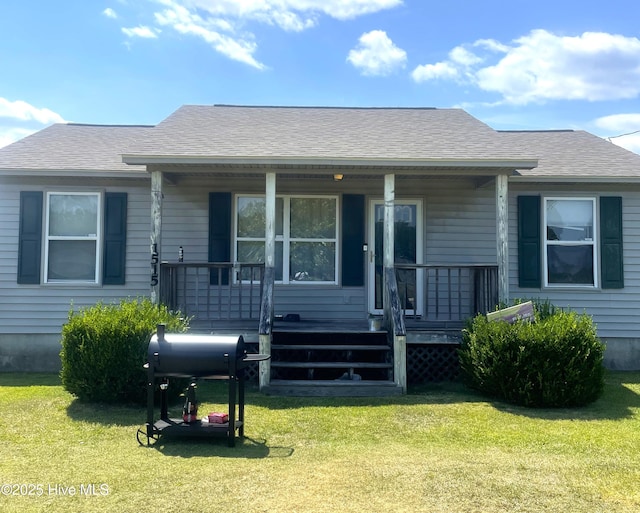 bungalow-style house featuring a front yard, a porch, and roof with shingles