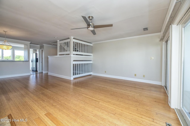 unfurnished living room featuring ornamental molding, a ceiling fan, baseboards, and light wood-type flooring