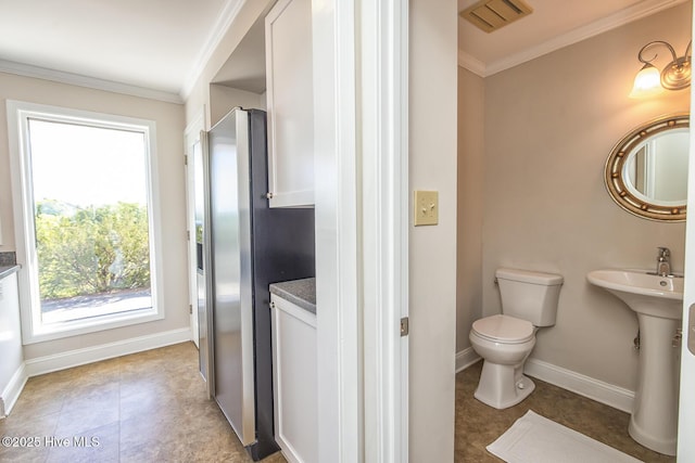 bathroom featuring crown molding, toilet, baseboards, and tile patterned floors